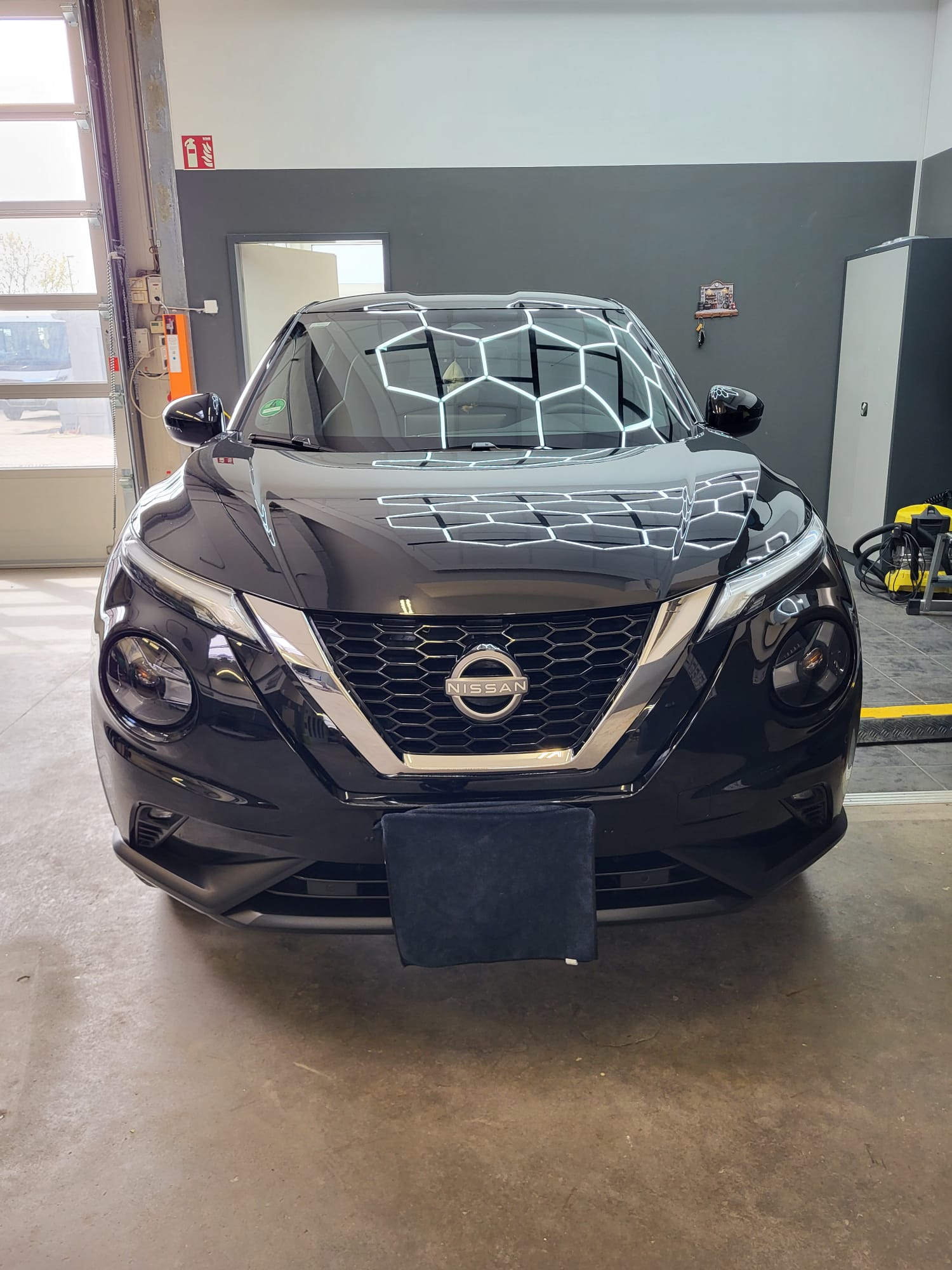 Schwarzer Nissan in der Meisterlack-Werkstatt mit glänzendem Finish