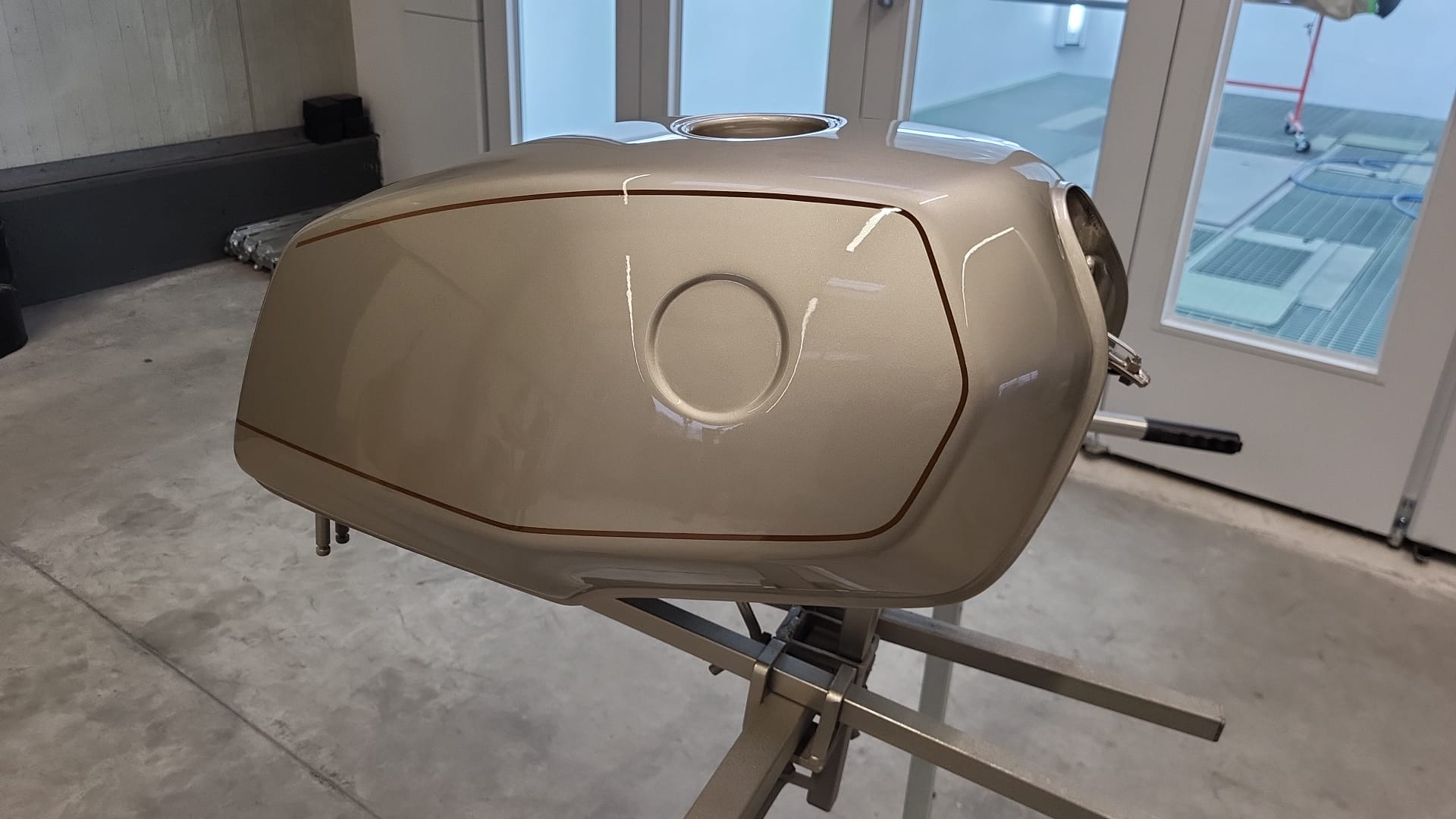 Hell lackierter Motorradtank mit dunkler Zierlinie