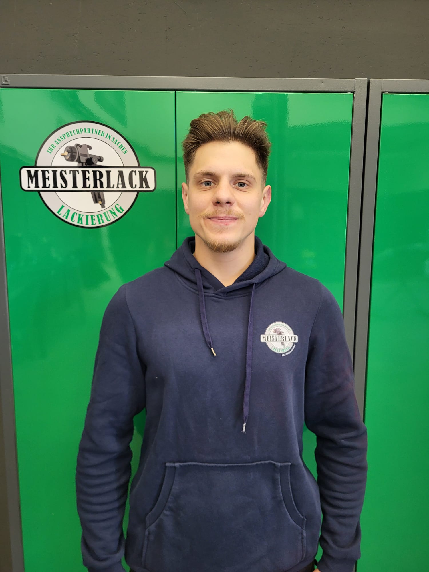 Steven vor dem Meisterlack Werkstattlogo